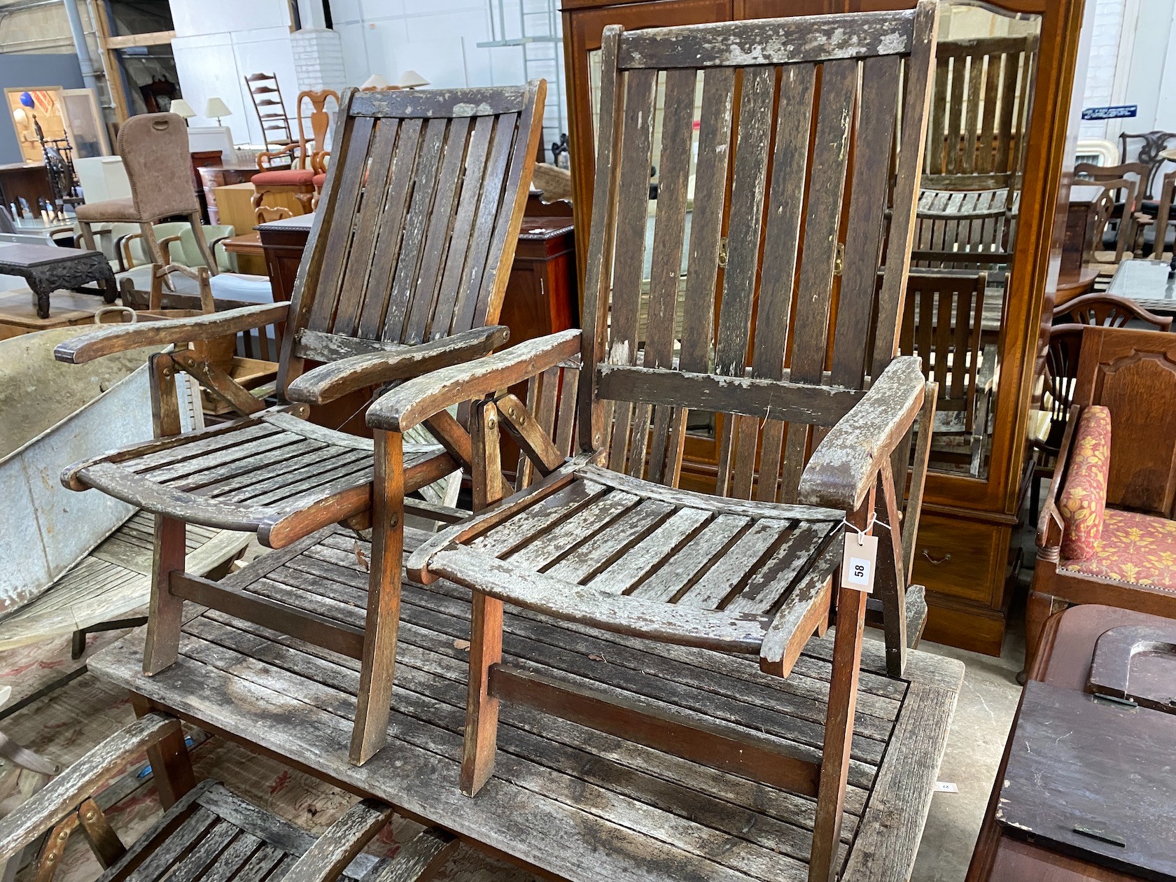 A rectangular weathered teak garden table, length 151cm, depth 70cm, height 73cm and six folding elbow chairs